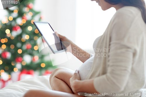 Image of close up of pregnant woman with tablet pc at home