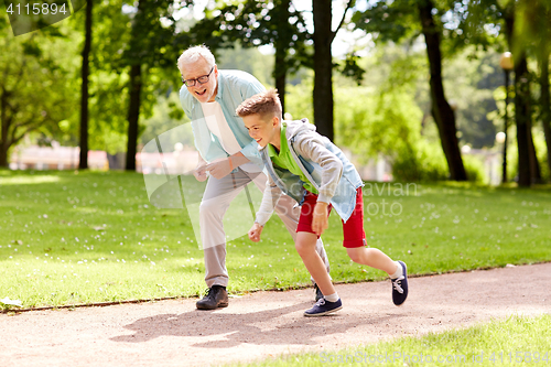 Image of grandfather and grandson racing at summer park