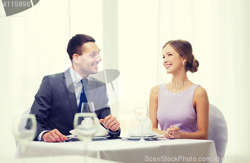 Image of smiling couple looking at each other at restaurant