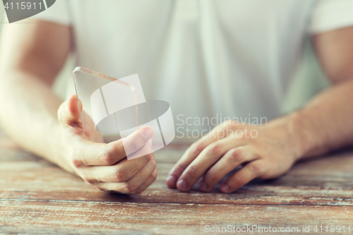 Image of close up of male hand with transparent smartphone