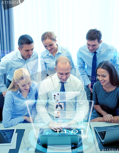 Image of smiling business people with laptop in office