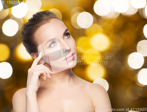 Image of beautiful young woman touching her face