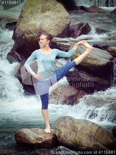 Image of Woman doing Ashtanga Vinyasa Yoga asana outdoors at waterfall