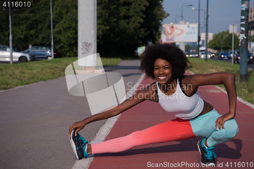 Image of Portrait of sporty young african american woman stretching outdo