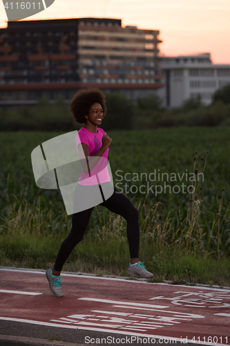 Image of a young African American woman jogging outdoors