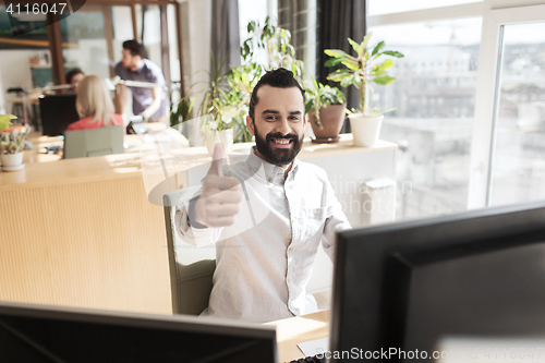 Image of happy male office worker showing thumbs up