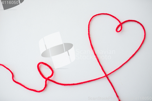 Image of red knitting yarn thread in shape of heart