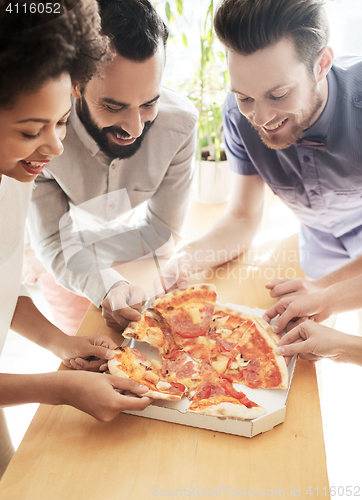 Image of happy business team eating pizza in office
