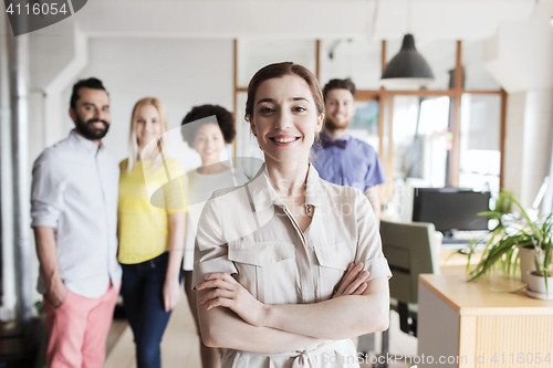 Image of happy young woman over creative team in office