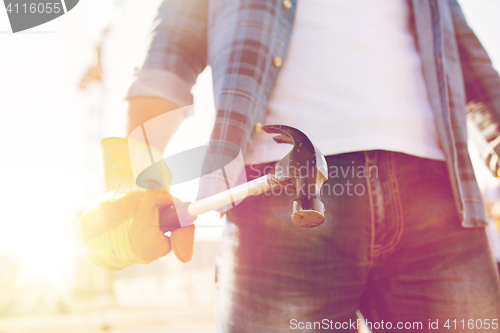 Image of close up of builder hand in glove holding hammer