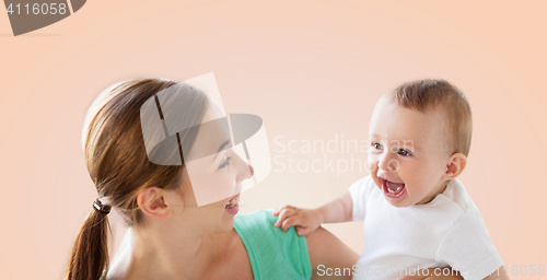 Image of happy young mother with little baby over beige