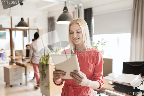 Image of happy creative female office worker with tablet pc