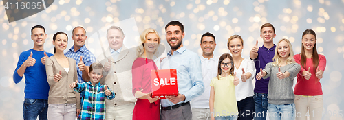 Image of happy people with sale sign showing thumbs up