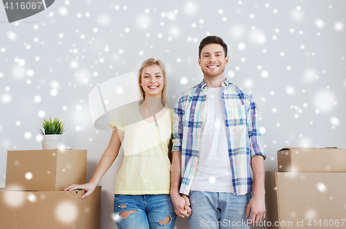 Image of smiling couple with big boxes moving to new home