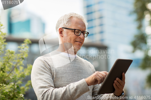 Image of senior man with tablet pc on city street