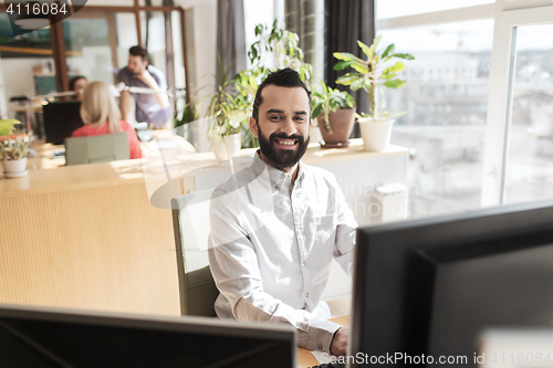 Image of happy creative male office worker with computer