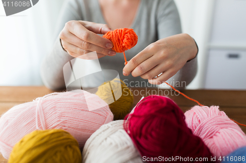 Image of woman pulling yarn up into ball