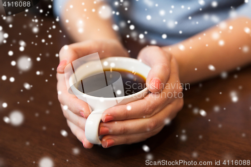 Image of close up of woman holding hot black coffee cup