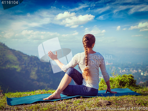 Image of Woman practices yoga asana outdoors