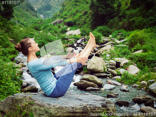 Image of Woman doing Ashtanga Vinyasa Yoga asana Navasana - boat pose