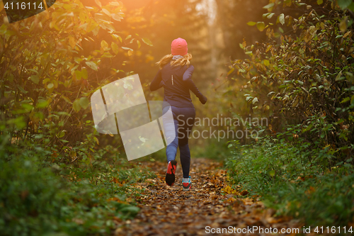 Image of Blonde woman running among trees