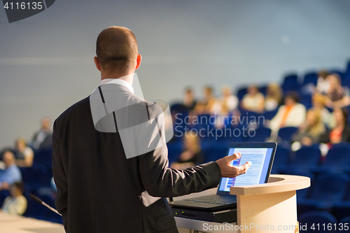 Image of Public speaker giving talk at business event.