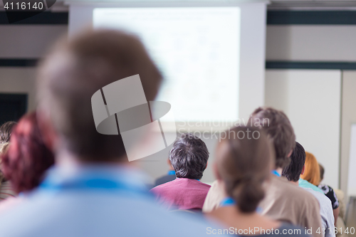 Image of Audience in lecture hall participating at business conference.