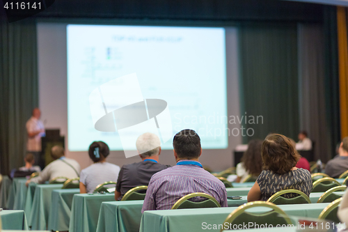 Image of Audience in lecture hall participating at business conference.