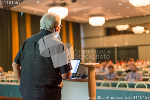 Image of Senior public speaker giving talk at scientific conference.