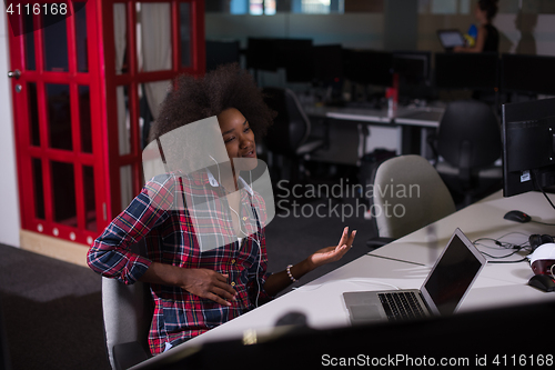 Image of woman at her workplace in startup business office listening musi