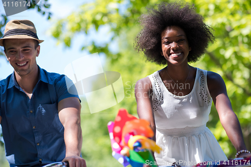 Image of Young  couple having joyful bike ride in nature