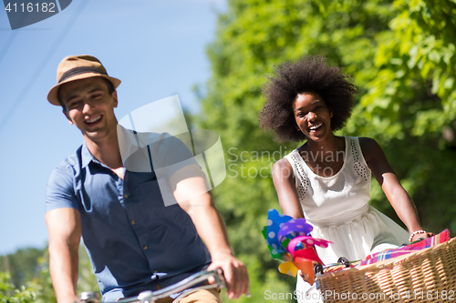 Image of Young  couple having joyful bike ride in nature