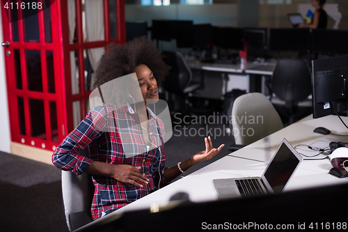 Image of woman at her workplace in startup business office listening musi