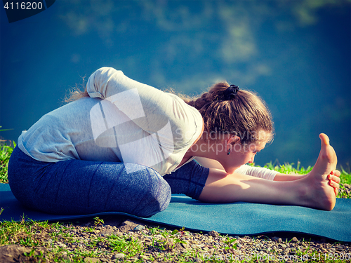 Image of Woman doing yoga asana outdoors