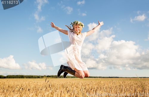 Image of happy woman in wreath jumping on cereal field