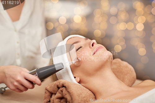 Image of close up of young woman having face massage in spa