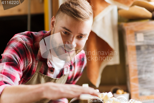 Image of carpenter working with wood plank at workshop