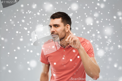 Image of man having hearing problem listening to something