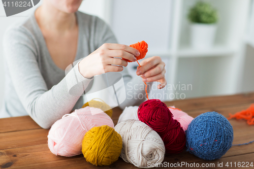 Image of woman pulling yarn up into ball