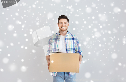 Image of smiling young man with cardboard box at home