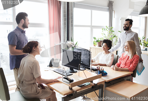 Image of happy creative team talking in office