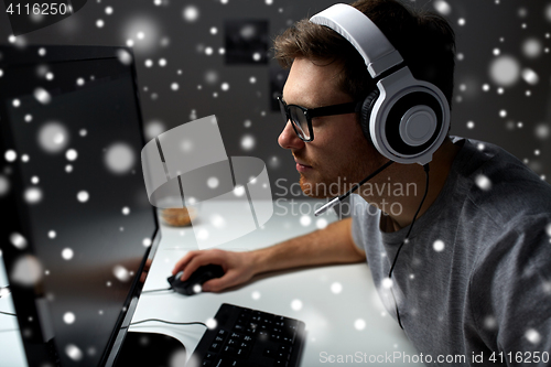 Image of man in headset playing computer video game at home