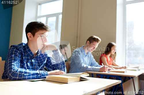 Image of group of students with books writing school test