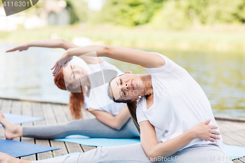 Image of women making yoga exercises outdoors