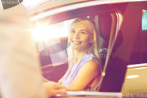 Image of happy woman with car dealer in auto show or salon