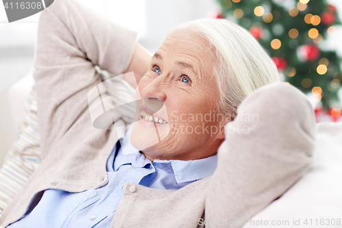 Image of happy senior woman resting on sofa at home