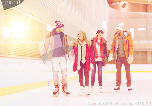 Image of happy friends on skating rink