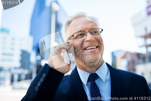 Image of smiling old businessman calling on smartphone