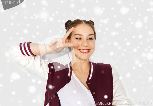 Image of happy smiling teenage girl showing peace sign