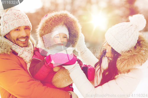 Image of happy family with child in winter clothes outdoors
